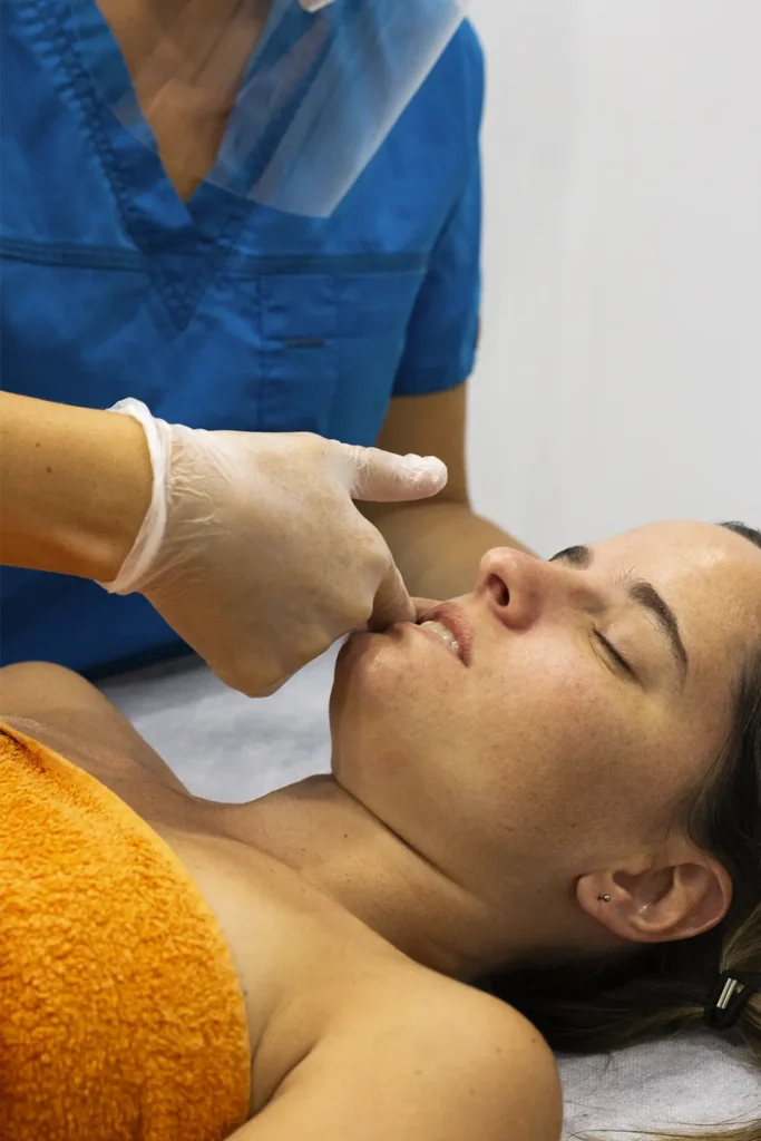 Fisioterapeuta realizando tratamiento intraoral de la articulación temporomandibular (ATM) en clínica de Madrid